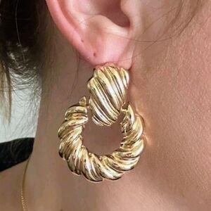 Gold dangle doorknocker earrings; one sided